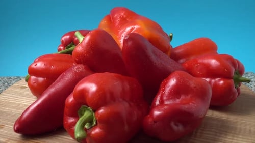 Fresh Red Bell Peppers Heap on Cutting Board