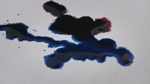 Red and Blue Liquids Spreading on White Surface