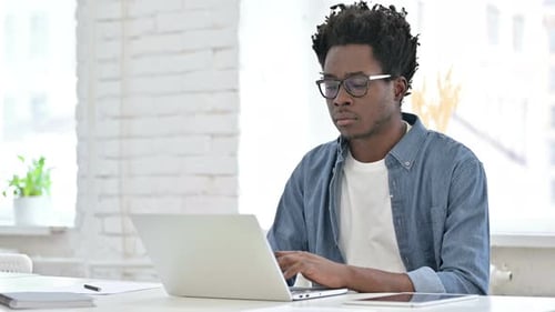 Young Adult Working at Computer in Bright Office