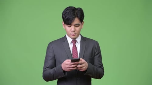 Young Adult in Suit Using Smartphone Device