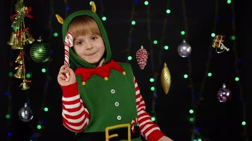 Child Dressed as Elf Holding Candy Cane