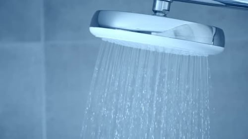 Shower Head at Tiled Bathroom Interior