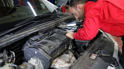 Mechanic Examining Car Engine in Auto Repair Shop