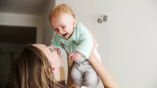 Mother Holding Baby in the Air Close Up