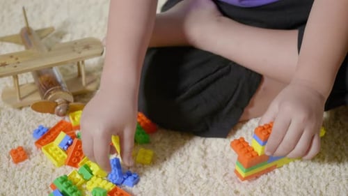 Child Plays with Colorful Building Blocks and Toys