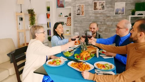 Family and Friends Toasting at Dinner Table