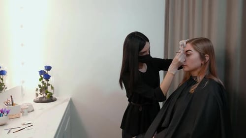 Woman Shaping Eyebrows in a Beauty Salon