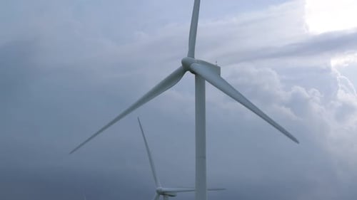 Large Grey Blades Rotate on Energy Generator Windmills Row