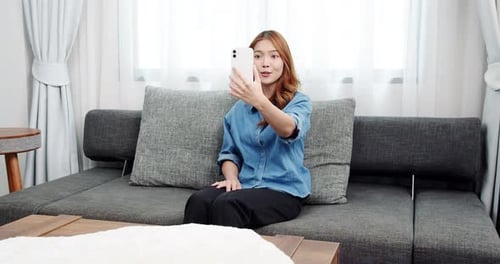 Woman on Couch Video Calling with Smartphone