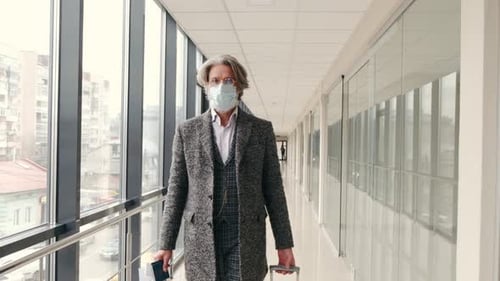 Old Hipster Man in Grey Suit with Suitcase Going Along the Airport Hall