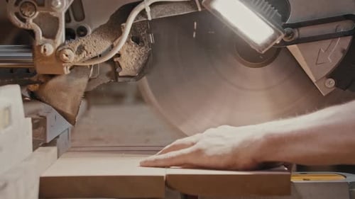 Carpentry Works Worker Slowly Cutting Along the Wooden Detail with a Big Circular Saw