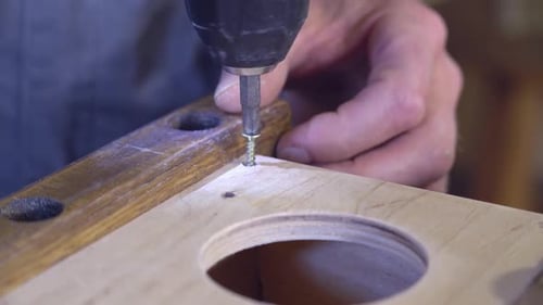 Man Boring Holes Using Steel Drill Indoors