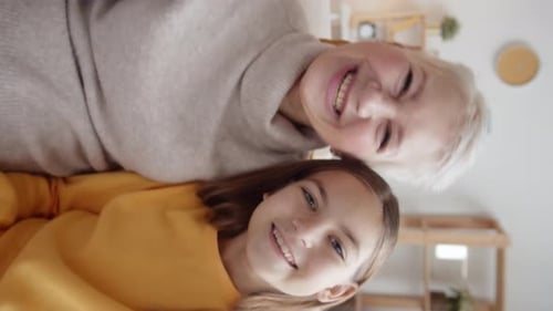 Smiling Child and Senior Waving Indoors