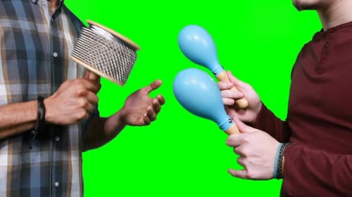 Sección media de músicos masculinos tocando cabasa y maraca