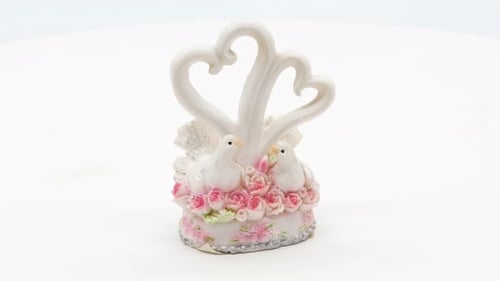 Estatuilla de dos palomas blancas sobre fondo blanco