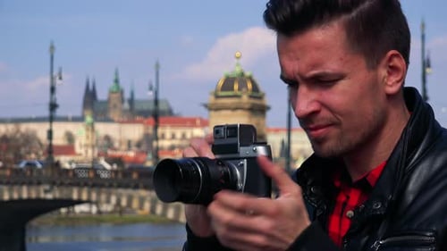 A Young Handsome Man Takes Photos with a Camera - Face Closeup - a Quaint Town