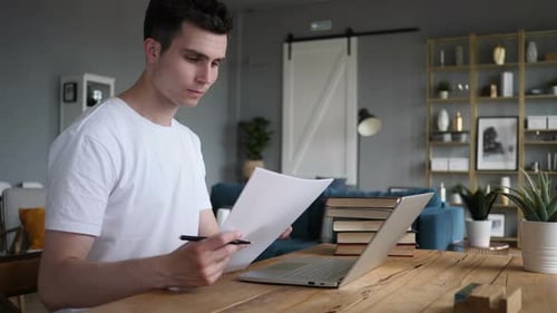 Young Adult Working at Laptop at Home