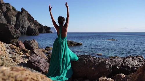 Side View a Young Beautiful Sensual Woman with Black Hair in a Long Mint Dress Posing on a Beach