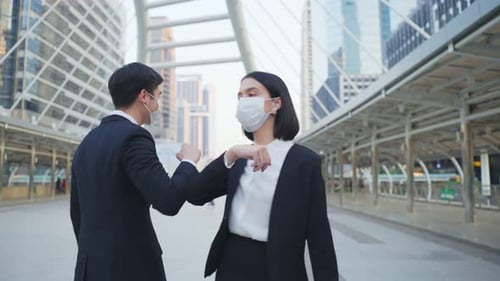 Asian business people wearing protective face mask outside in city during covid pandemic.