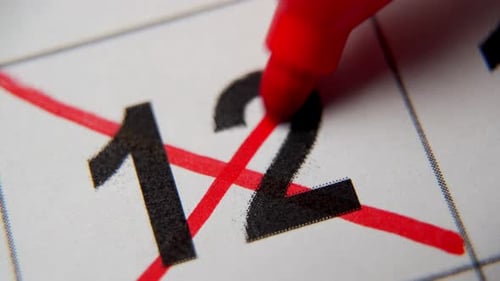 El número 12 del calendario está tachado con una cruz roja en una macro en una hoja blanca