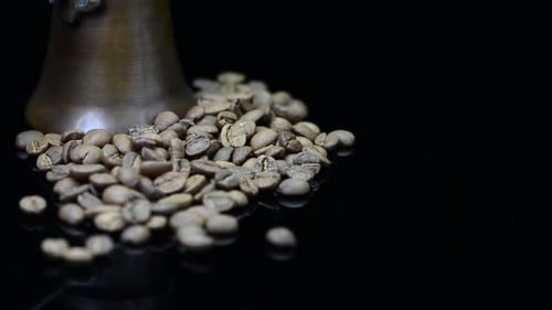 coffee beans and coffee pot on black mirror