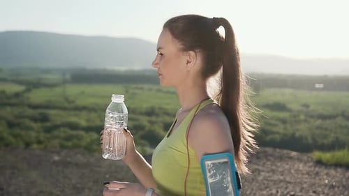 Woman Drinks Water After Outdoor Exercise