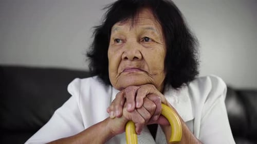 close up of senior woman with wooden cane