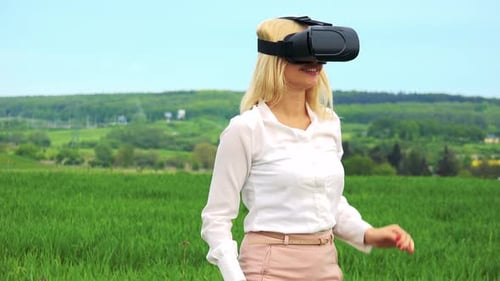 Woman Experiences Virtual Reality in a Green Field