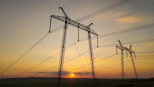 Electrical Pylons in Rural Landscape at Golden Hour