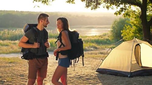 Young Couple Camping at Sunset by Lake