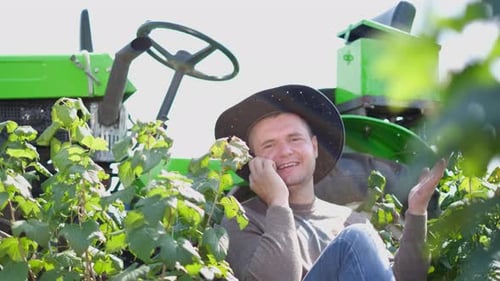 Happy Man Talking on Phone by Tractor
