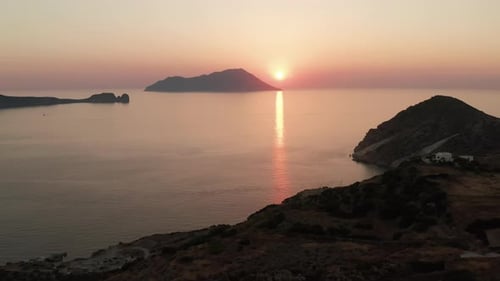 Slow Tilt Up Revealing Beautiful Tropical Island Coast with Sunset Over Ocean