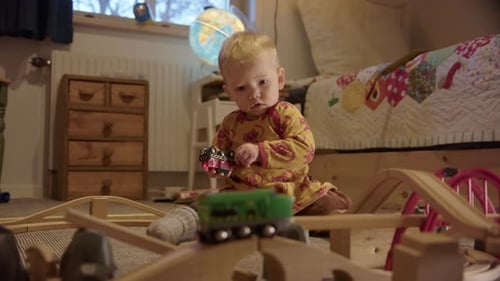 Blond Infant Playing With Toy Train Set Indoors