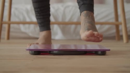 Legs Step onto Bathroom Scale for Weight Measurement