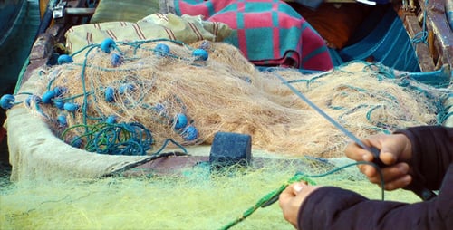 Fisherman repariert Netzstrümpfe