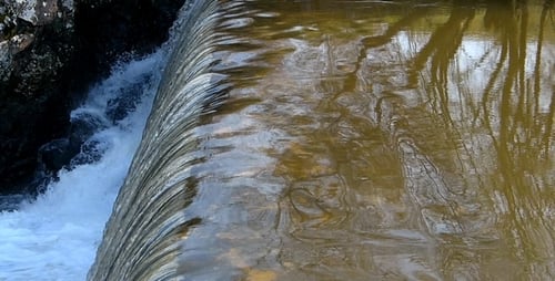 Water Flowing Over Small Dam in Nature