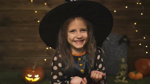 Happy Girl in Witch Costume with Jack-o-Lantern Bucket