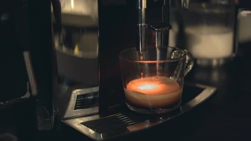 Espresso Machine Pouring Fresh Coffee into Glass Mug