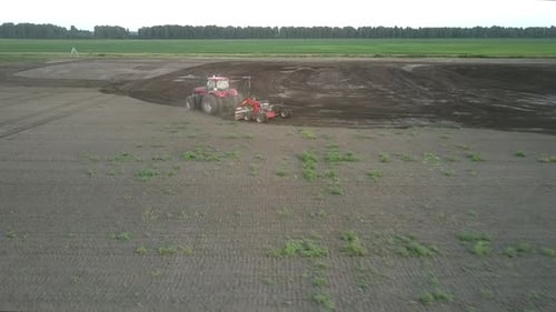 Tractor Cultivates Soil with Harrow at Farmland Aerial View