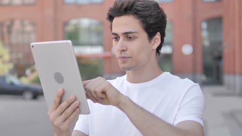 Man Using Tablet While Standing Outdoor