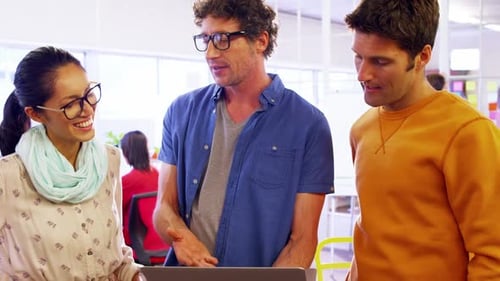 Team Discussing Project on Laptop in Bright Office