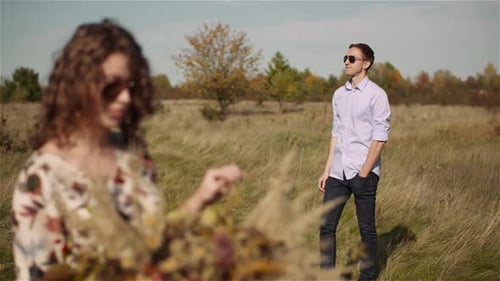 Young Couple Walking on a Meadow