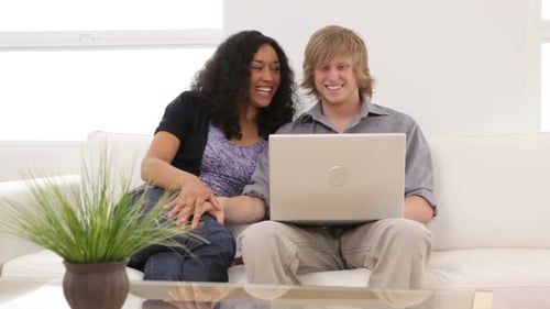 Woman and Man Using Laptop on Couch at Home