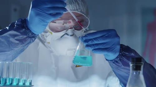 Virologe in Schutzausrüstung führt chemisches Experiment im Labor durch