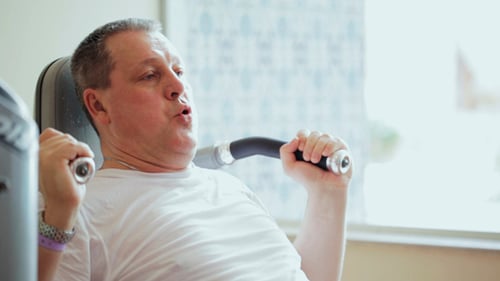 Man Works Out on Weight Machine Indoors