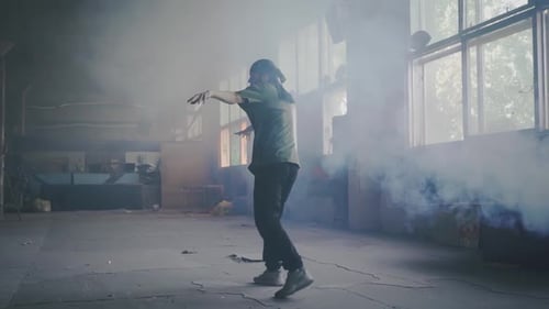 Young Man Dancing in Smoky Abandoned Building