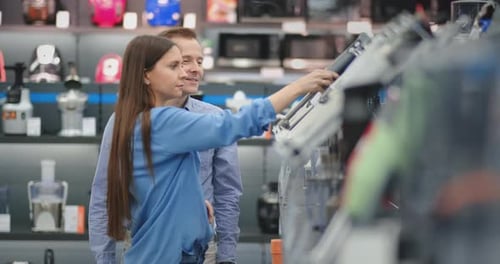 In the Appliances Store, a Married Couple in Everyday Clothes Chooses a Blender for the Purchase By