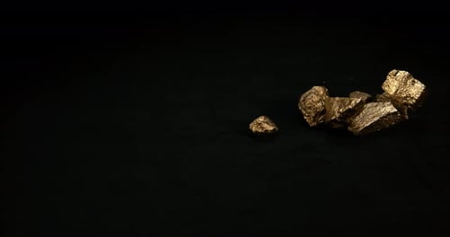 Nuggets de oro, pepita, caída sobre fondo negro, cámara lenta 4K