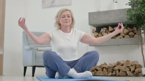 Blonde Senior Woman Meditates in Living Room