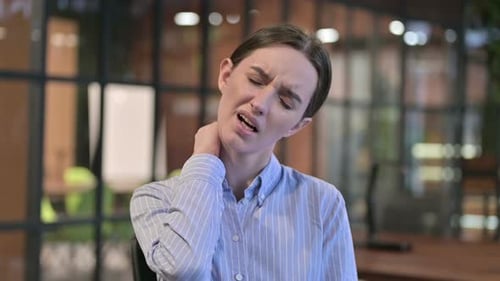 Woman Massaging Stiff Neck in Office Setting